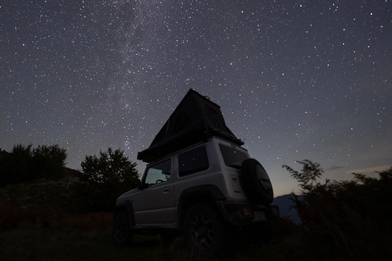 Suzuki Jimny under the Milky Way in the Albanian mountains